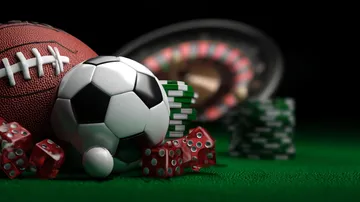 A man celebrating a winning moment on his laptop while gaming symbols float around him, capturing the excitement of YAMANPLUS games.